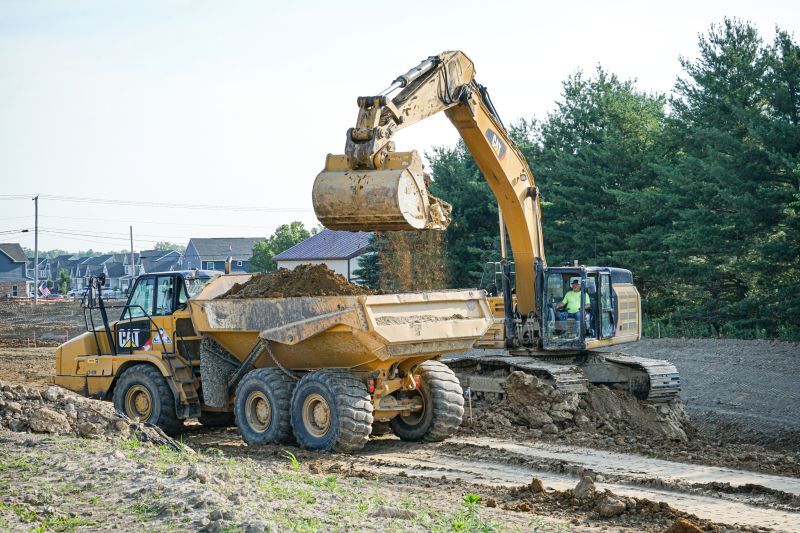 excavator putting dirt into dump truck