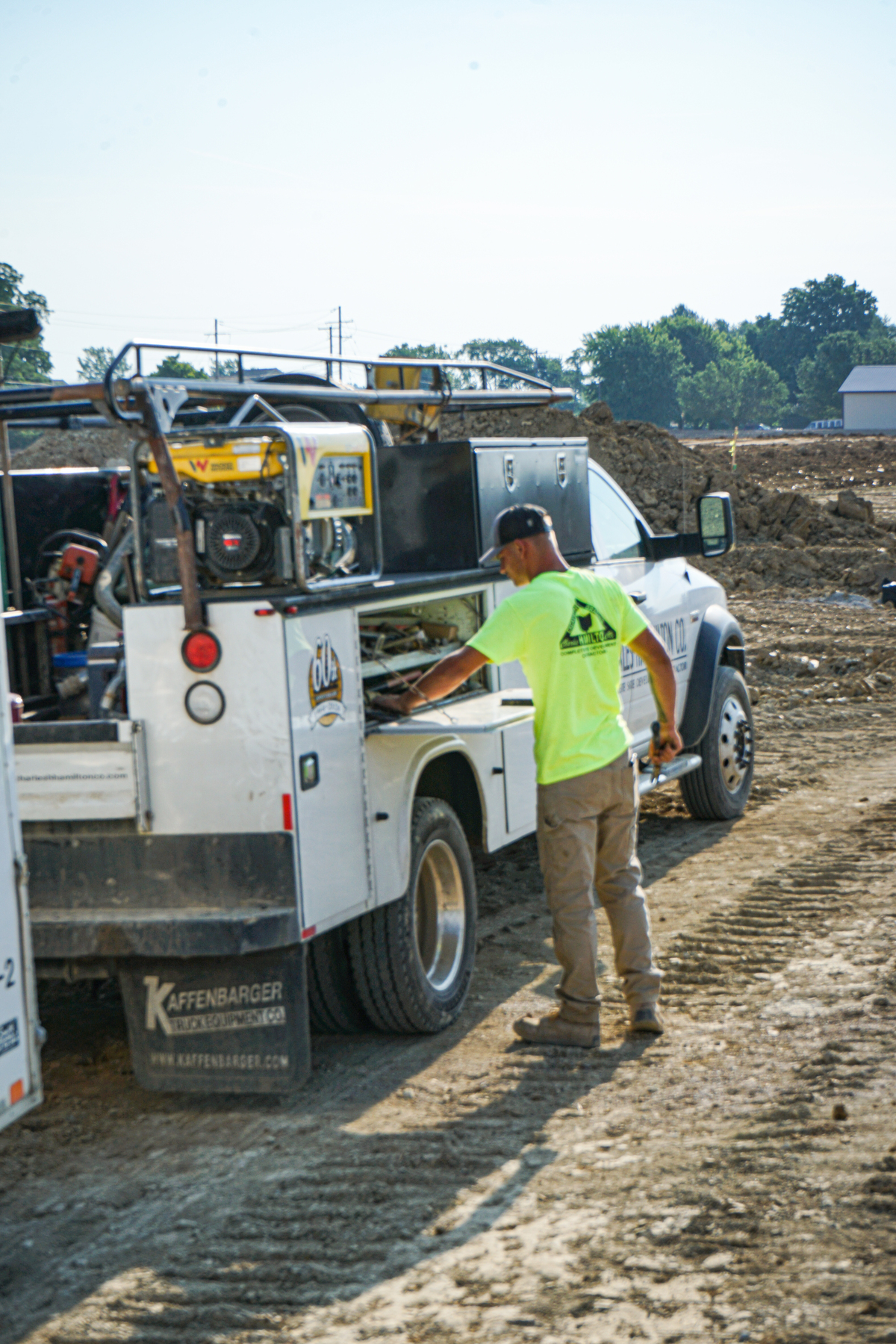 Construction worker getting tools out of work truck on site