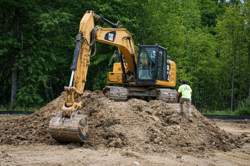 excavator on a dirt hill digging
