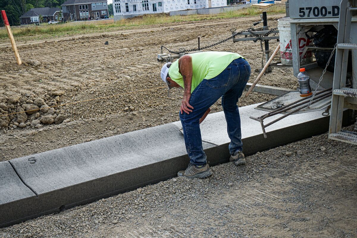 construction workers smoothing out concrete curb 