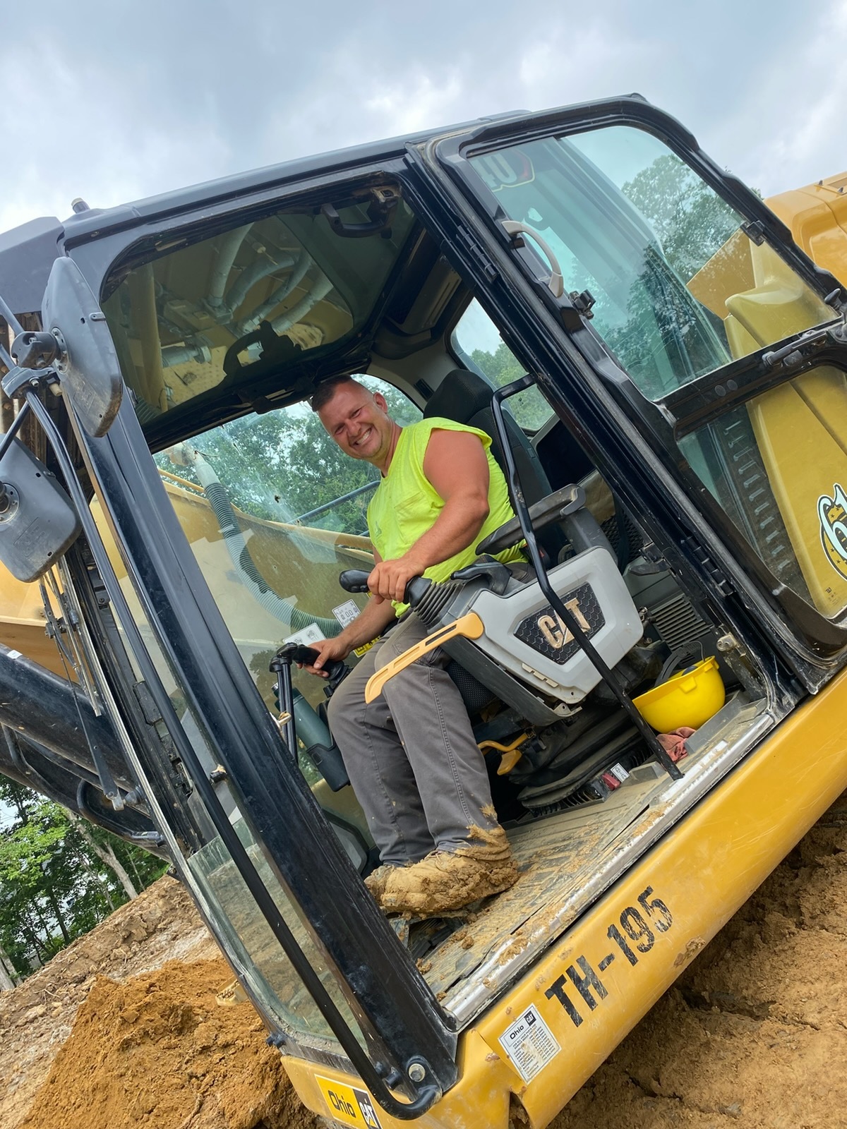 Smiling heavy machinery operator in construction equipment 