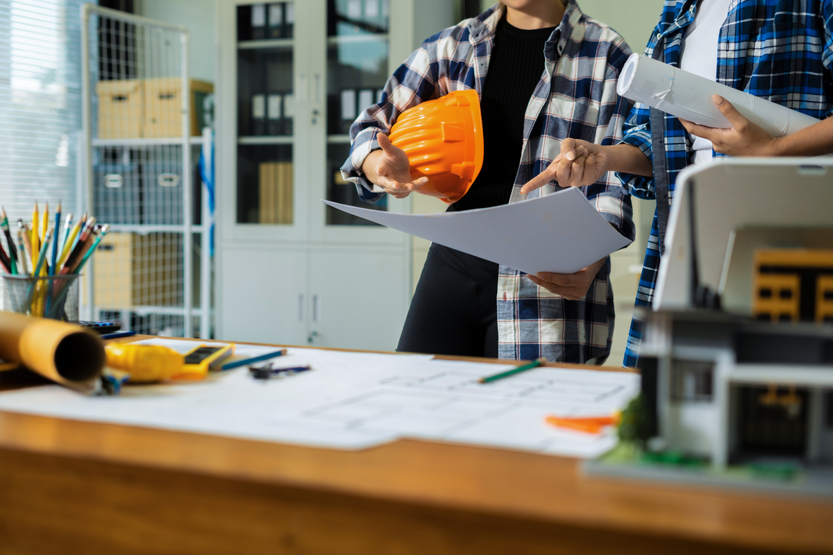 contractors in an office looking over blueprints
