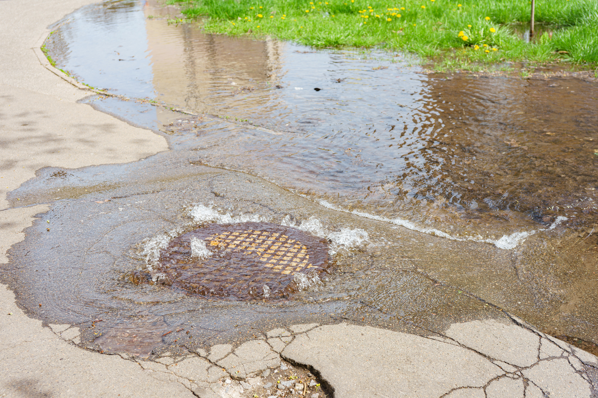 water pouring out from sewer grate
